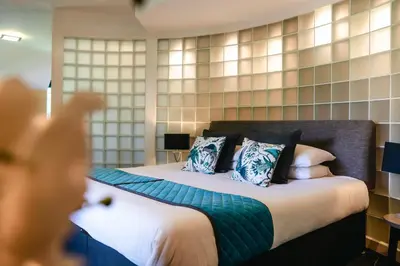 a hotel room with a bed with a person taking a picture at Wild Pheasant Hotel & Spa in Llangollen