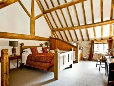 a bedroom with a bed and a table in a room at Old Downton Lodge in Downton