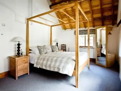 a bedroom with a bed with a wooden canopy at Old Downton Lodge in Downton