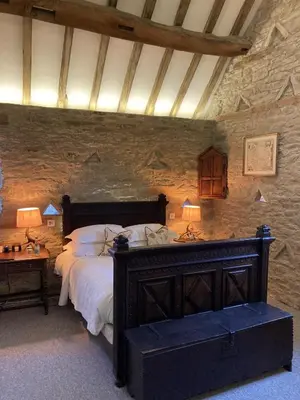 a bedroom with a large bed in a stone wall at Old Downton Lodge in Downton