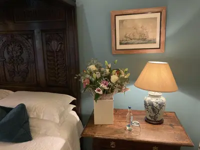 a bedroom with a bed and a table with a lamp at Old Downton Lodge in Downton