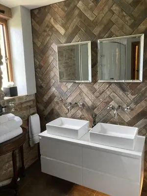 a bathroom with two sinks and two mirrors at Old Downton Lodge in Downton