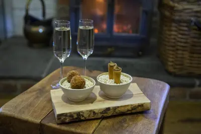 a table with two wine glasses and two bowls of food at Old Downton Lodge in Downton