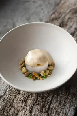 a white bowl with ice cream and nuts on a table at Old Downton Lodge in Downton