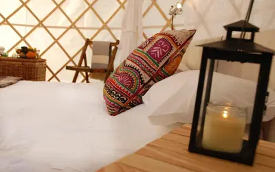 a bedroom with a bed with a candle and a pillow at Festival Yurts Hay-on-Wye in Hay-on-Wye