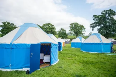a group of blue and white tents in a field at Festival Yurts Hay-on-Wye in Hay-on-Wye