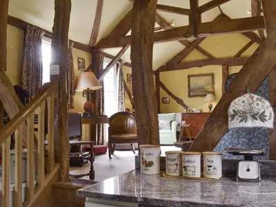a living room with wooden beams in a house at Dolgenau Cottages in Trefeglwys