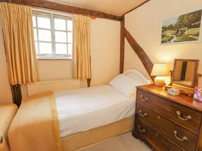 a bedroom with a bed and a dresser and a mirror at Dolgenau Cottages in Trefeglwys