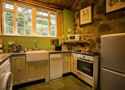 a kitchen with a sink and a stove at Dolgenau Cottages in Trefeglwys