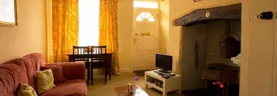 a living room with a couch and a tv at Church Lane Cottage in Llanidloes