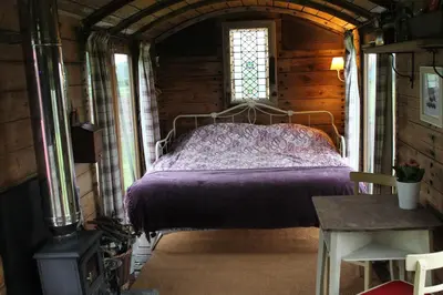 a bedroom with a bed in a wooden cabin at Off the Rails in Oswestry