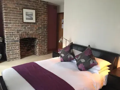 a bedroom with a bed with a brick fireplace at Ty Morgan's in Rhayader