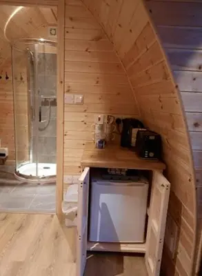 a small bathroom with a shower and a sink at Bwlcheinion Sea View Glamping in Machynlleth