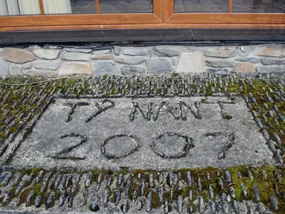 a sign written on the ground in front of a building at Ty Nant in Llanon