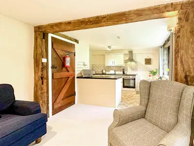 a living room with two chairs and a kitchen at Kite 1 - Uk6549 in Llanfihangel-Bryn-Pabuan