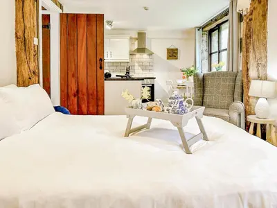 a bedroom with a white bed with a table on it at Kite 1 - Uk6549 in Llanfihangel-Bryn-Pabuan