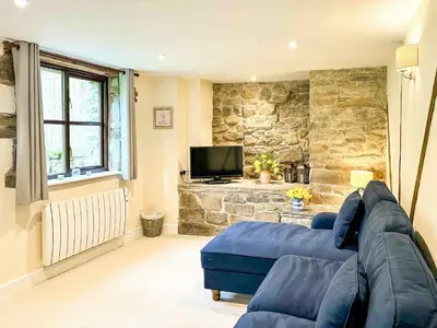 a living room with a blue couch and a tv at Kite 1 - Uk6549 in Llanfihangel-Bryn-Pabuan