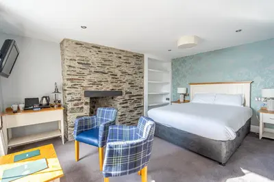 a hotel room with a bed and two chairs at Penhelig Arms in Aberdyfi