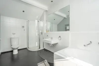 a white bathroom with a toilet and a sink at Penhelig Arms in Aberdyfi