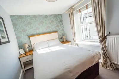 a bedroom with a large bed and a window at Penhelig Arms in Aberdyfi