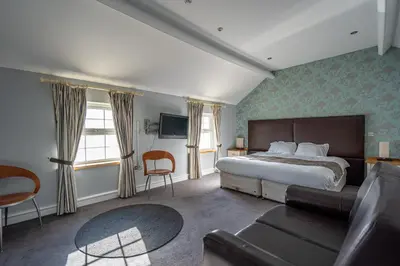 a hotel room with a bed and a couch at Penhelig Arms in Aberdyfi