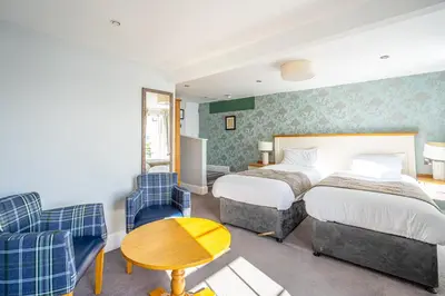 a hotel room with a bed and a table and chairs at Penhelig Arms in Aberdyfi