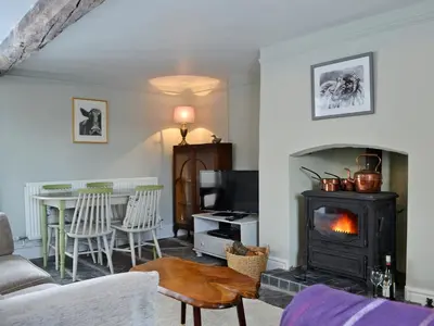 a living room with a stove and a table with chairs at The Cider Barn in Presteigne