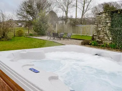 a jacuzzi tub in a yard at Bwthyn Bach in Dyffryn