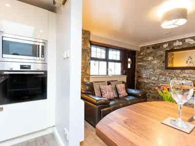 a living room with a couch and a table at Bwthyn Clyd in Dyffryn