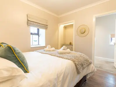 a bedroom with a large bed with two towels on it at Bwthyn Clyd in Dyffryn
