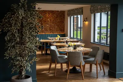 a restaurant with tables and chairs and a potted plant at Penrhos Park in Aberystwyth