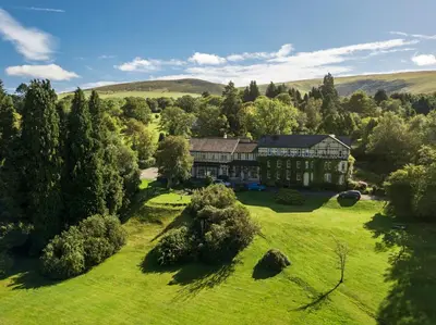 an aerial view of a large house on a green field at The Lake Country House Hotel & Spa in Llangammarch Wells