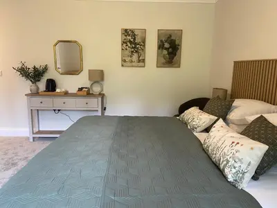 a bedroom with a bed and a dresser and a mirror at The Lake Country House Hotel & Spa in Llangammarch Wells