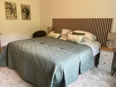 a bedroom with a bed with a striped headboard at The Lake Country House Hotel & Spa in Llangammarch Wells
