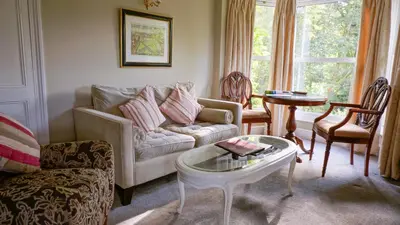 a living room with a couch and a table at The Lake Country House Hotel & Spa in Llangammarch Wells