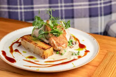 a plate of food with bread and vegetables on a table at The Castle Of Brecon Hotel, Brecon, Powys - The Coaching Inn Group in Brecon