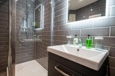 a bathroom with a sink and a shower at The Castle Of Brecon Hotel, Brecon, Powys - The Coaching Inn Group in Brecon