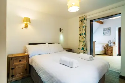 a bedroom with a bed with two towels on it at The Barn in Aberystwyth