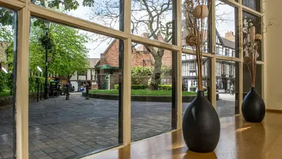 two vases sitting on a table in front of a window at Prince Rupert Hotel in Shrewsbury