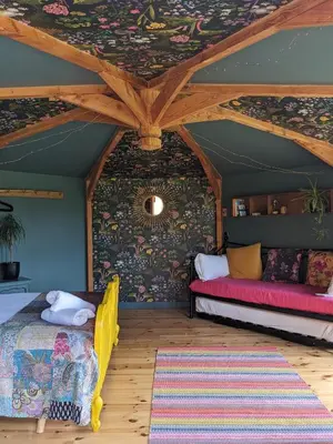 a room with two beds and a ceiling with flowers at Wye Glamping in Velindre