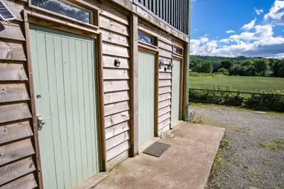 a garage with two doors on the side of a building at Wye Glamping in Velindre