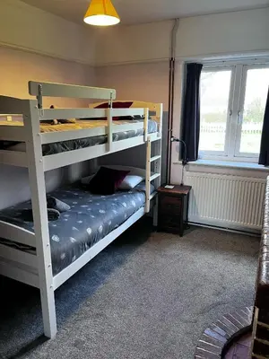 a bedroom with two bunk beds and a window at The Moorings in Fairbourne