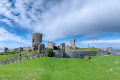 a castle on top of a grassy hill at Queensbridge Hotel in Aberystwyth