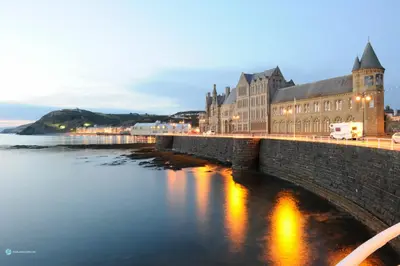 a bridge over the water in front of a building at Queensbridge Hotel in Aberystwyth
