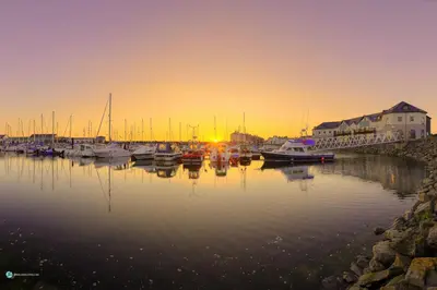 a group of boats docked in a harbor at sunset at Queensbridge Hotel in Aberystwyth