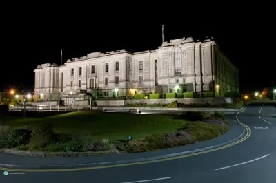 a large white building at night with a road in front at Queensbridge Hotel in Aberystwyth
