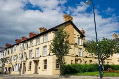 a large yellow building on a street with a street light at Four Seasons Hotel in Aberystwyth