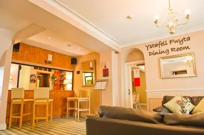 a living room with a couch and a dining room at Four Seasons Hotel in Aberystwyth