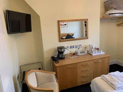 a room with a dresser with a mirror and a bed at Four Seasons Hotel in Aberystwyth