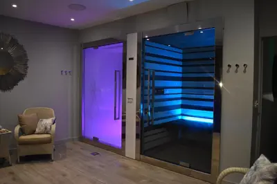 a room with a glass shower with purple lighting at Fishmore Hall Hotel and Boutique Spa in Ludlow
